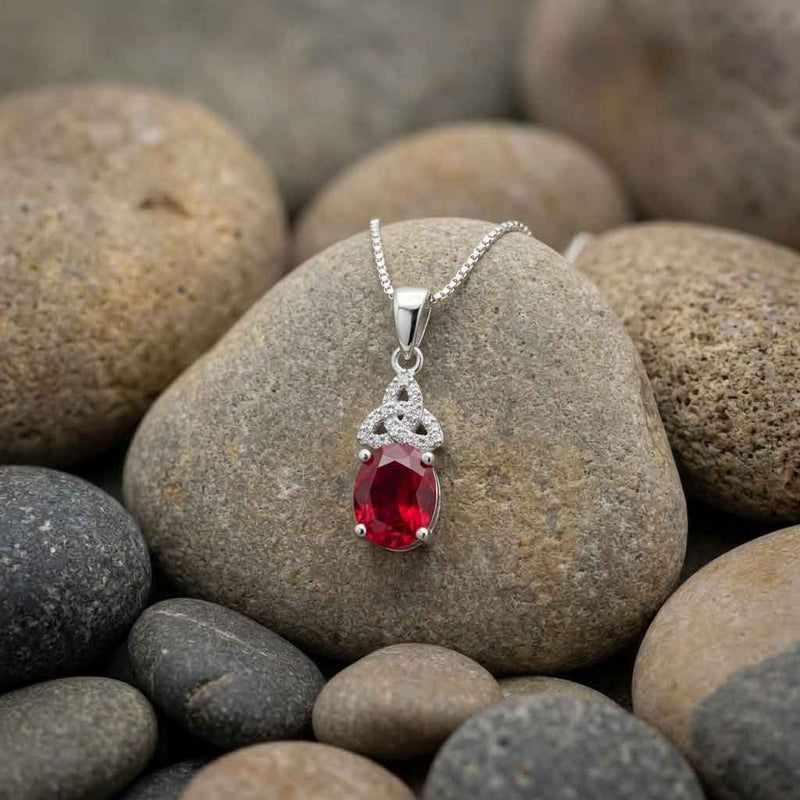 Irish Necklace Celtic Trinity Knot Crystal Birthstone Pendant displayed on stones