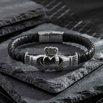 Rhodium Plated Leather Mens Claddagh Bracelet on a dark stone surface