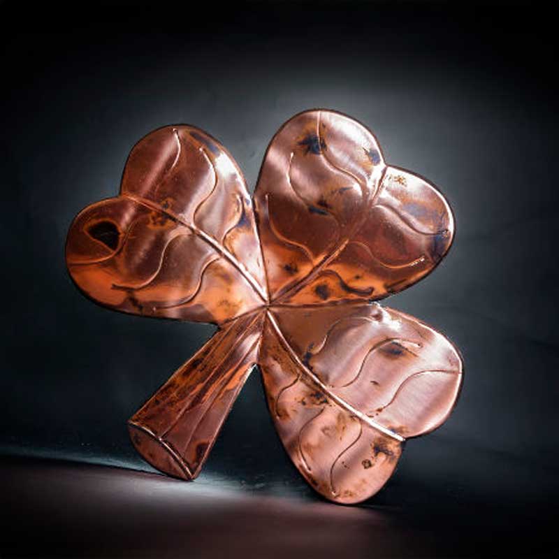 Copper Shamrock Wall Plaque in front of a dark backdrop