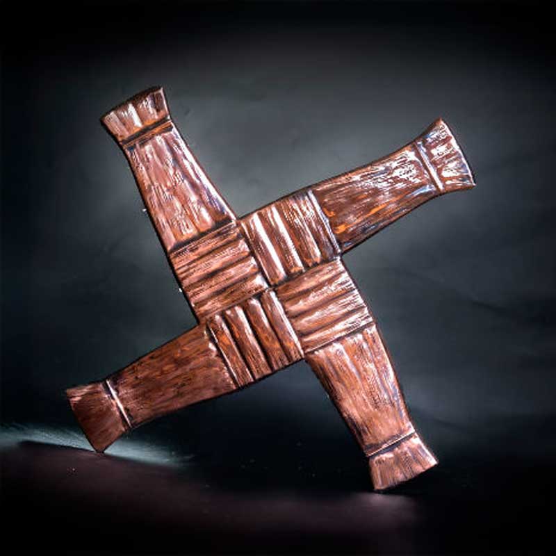 Copper St. Bridgets Cross Plaque in front of a dark backdrop