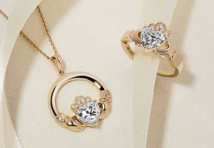 14k Gold Diamond Claddagh Ring and Necklace set on a soft beige background